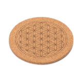 Ein runder Untersetzer aus Kork, in den das geometrische Muster der Blume des Lebens eingraviert ist.