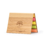 Aufgeklappter Notizblock aus Bambus mit bunten Haftnotizen und eingraviertem Lotus Vita Logo.