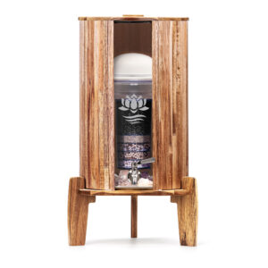 Ein Stand-Wasserfilter mit einem Gehäuse aus Akazienholz, einem sichtbaren Glasbehälter mit Filterkartusche und einem Zapfhahn aus Edelstahl.